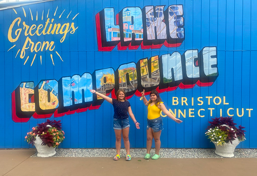 Photo of kids posing in front of Like Compounce sign
