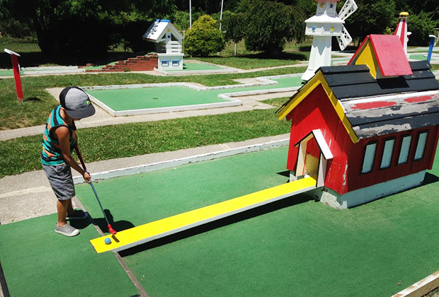 Mini-Golf Courses on Long Island boy putting in a mini golf course at Drossos Miniature Golf 