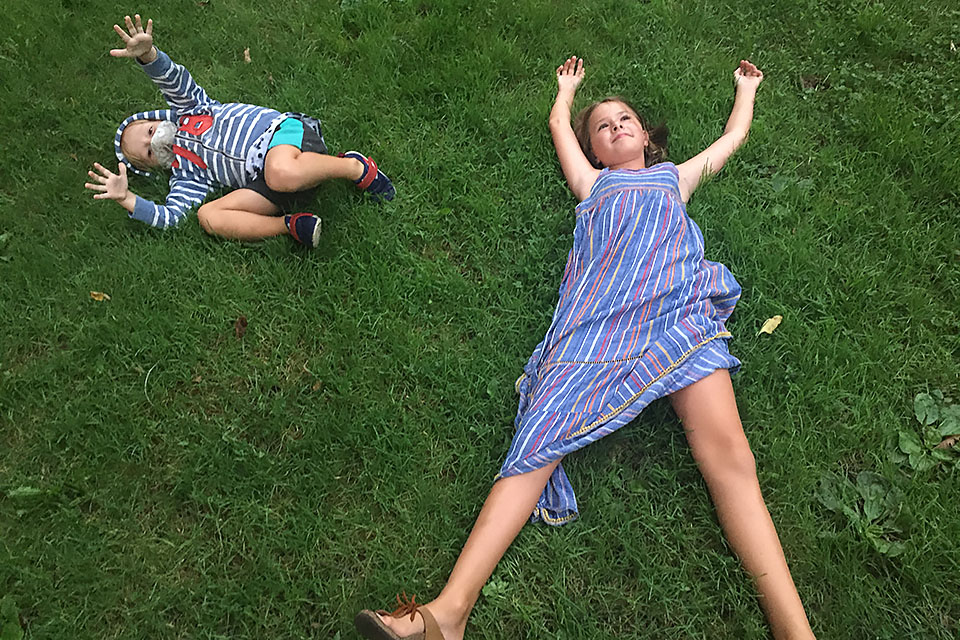 Boy and girl sprawl in grass at the Brooklyn Botanic Garden