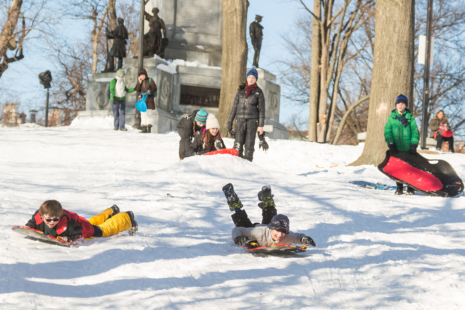 Photo of kids sledding on Flagstaff hill in Boston.