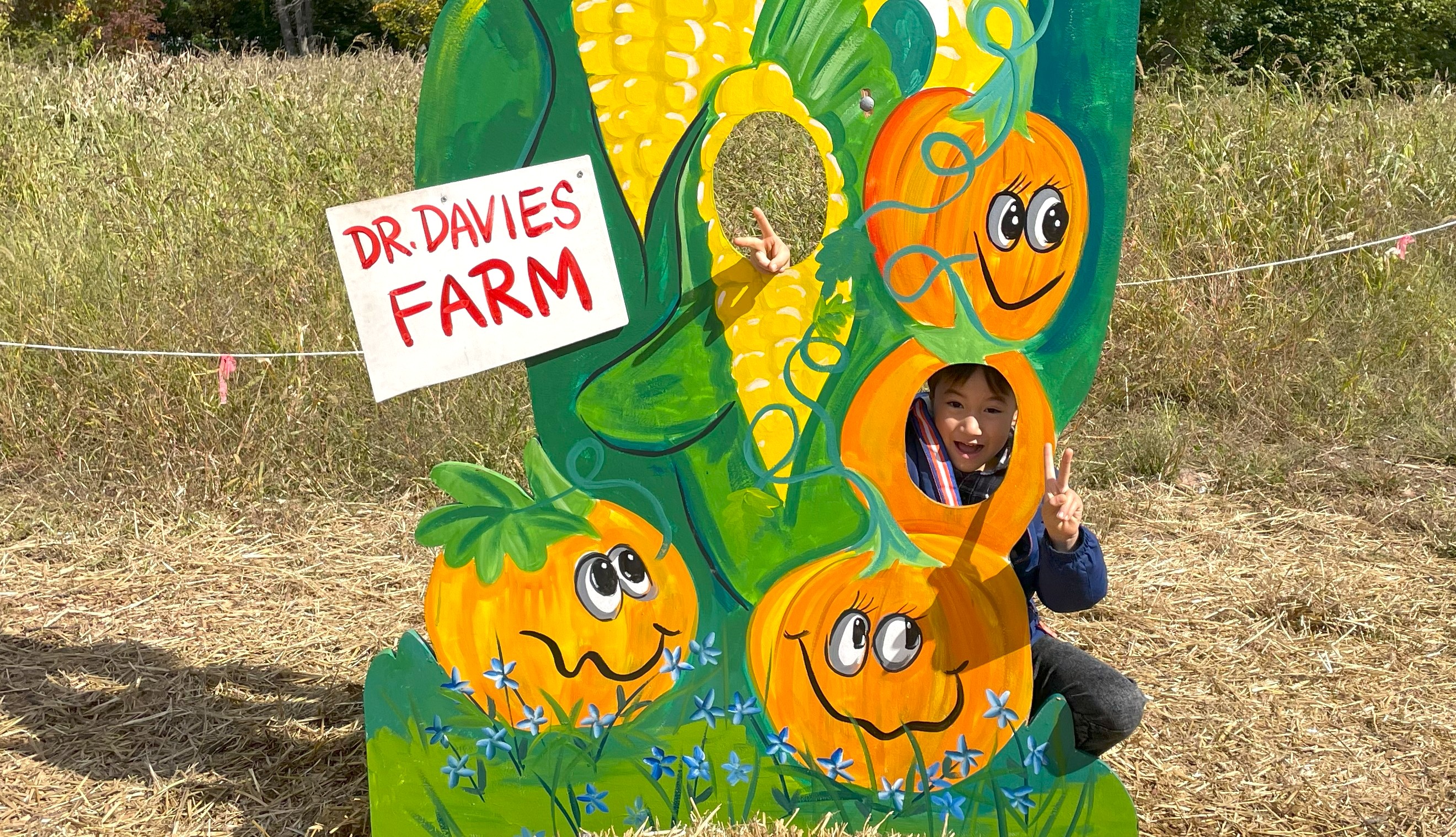 Hudson Valley fall family getaway: Boy posing with a sign at Dr. Davies Farm