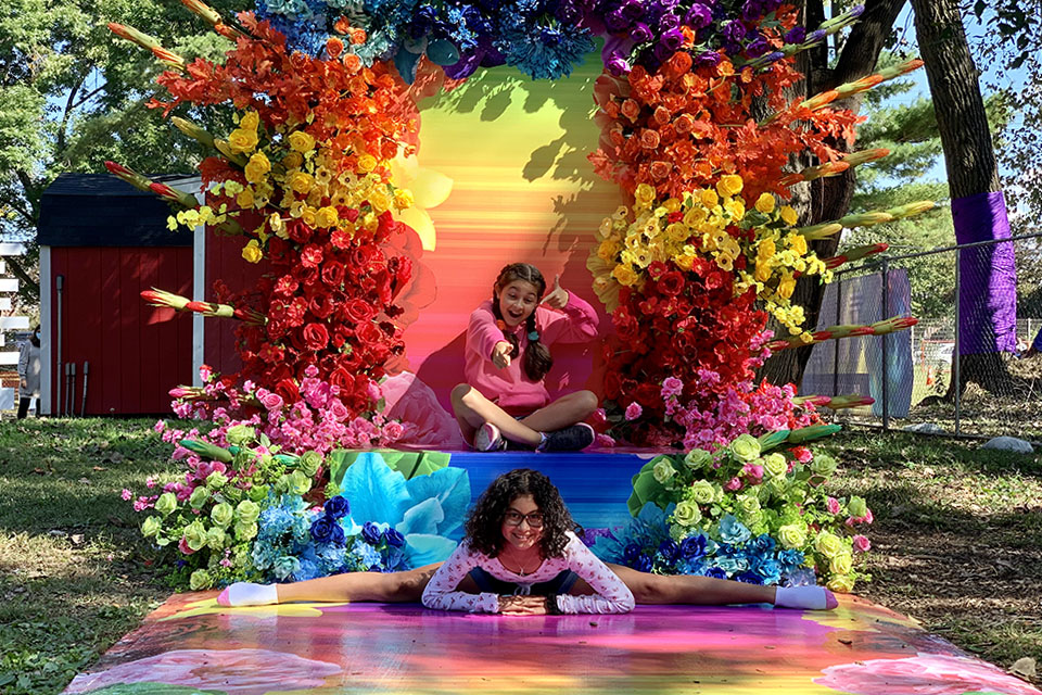 The blooms of The Fall Escape frame two girls striking a pose.