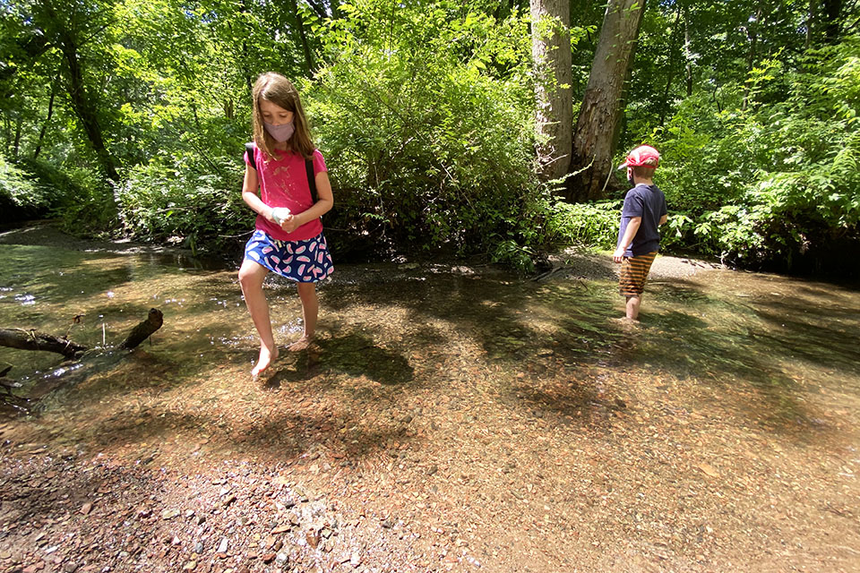 Hiking Games for Kids That Turn Walks into Adventures: kids wading in the water in a pond
