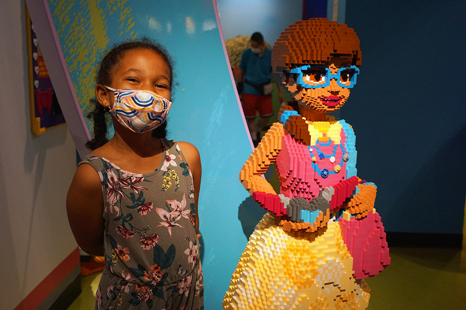 Girl poses with model of Lego Friends character at Legoland Discovery Center at American Dream.
