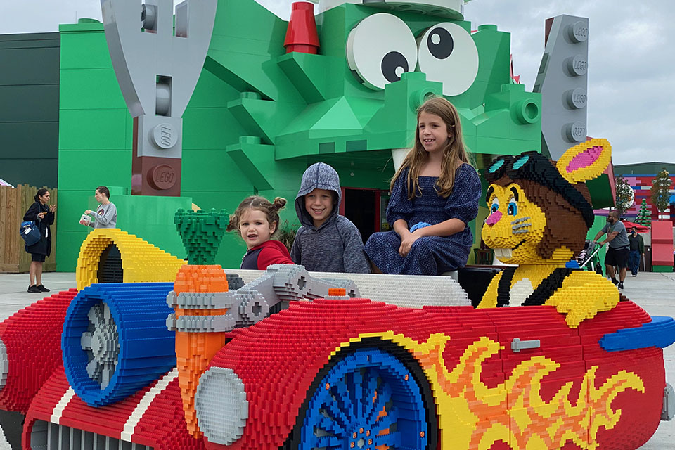Kids sit in a car at Legoland New York