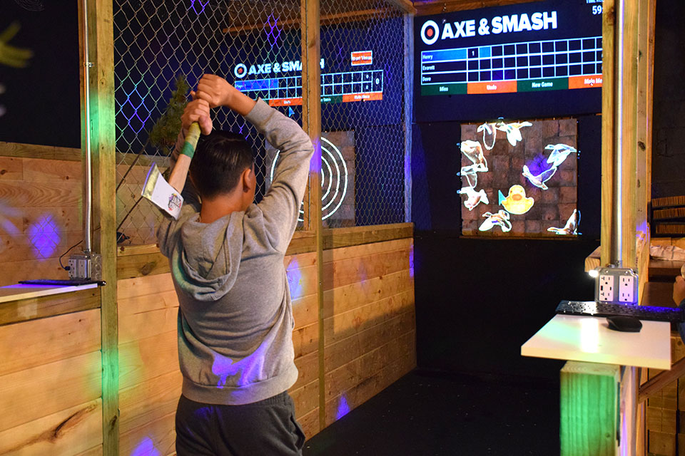 Experience the thrill of throwing an axe at a wooden target at Axe & Smash.
