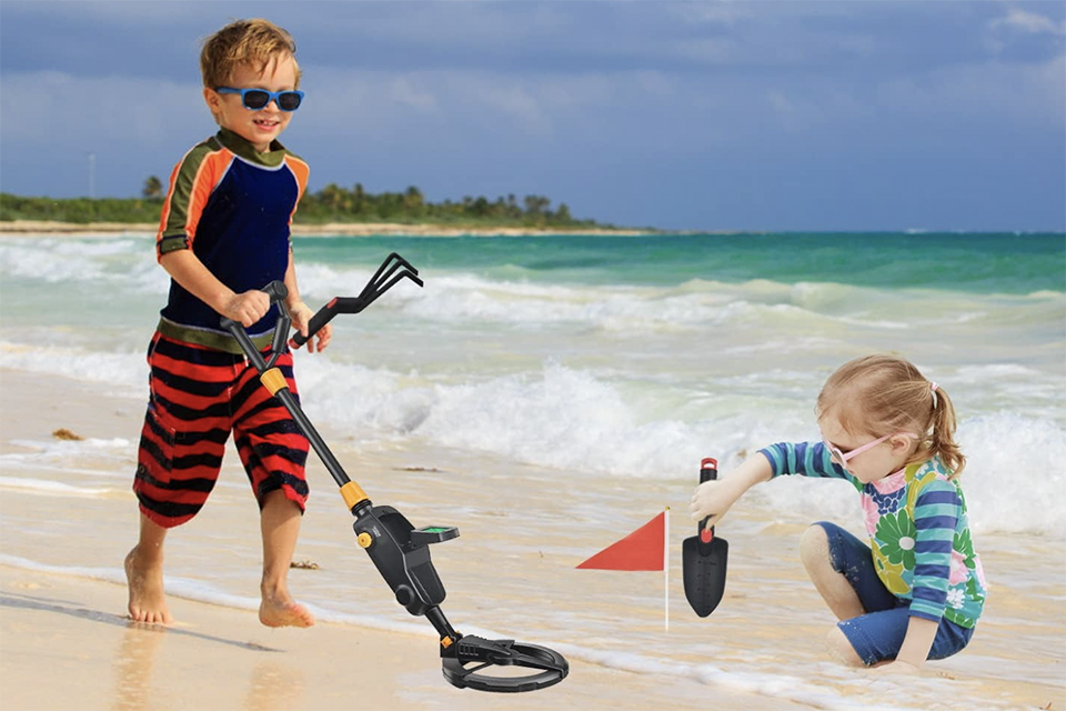 kids using metal detector on the beach