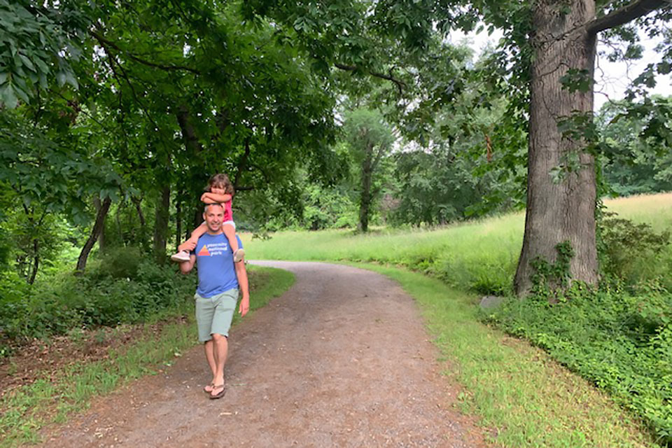 Father carrying daughter on shoulders in rockefeller state park