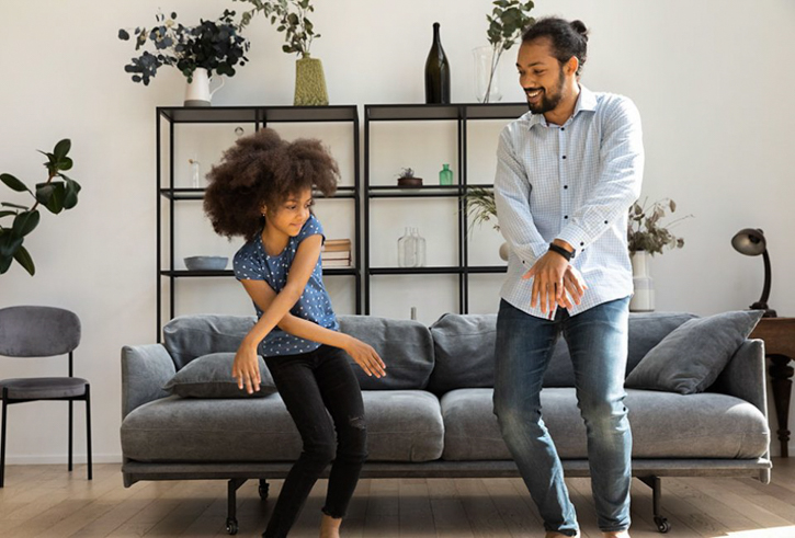 Father and daughter dance in their living room: Holidays & Activities for June 2025 National Dance Day