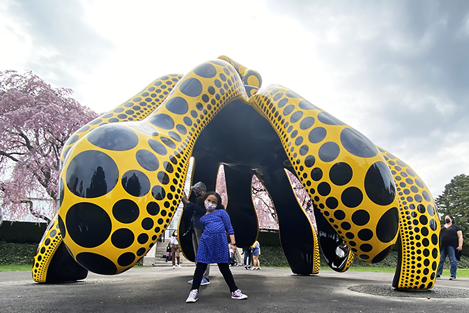 girl standing at Dancing Pumpkin kusama exhibit at NYBG