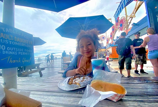 Girl having lunch on the Coney Island Board Walk: Summer Bucket List of Things To Do on Long Island
