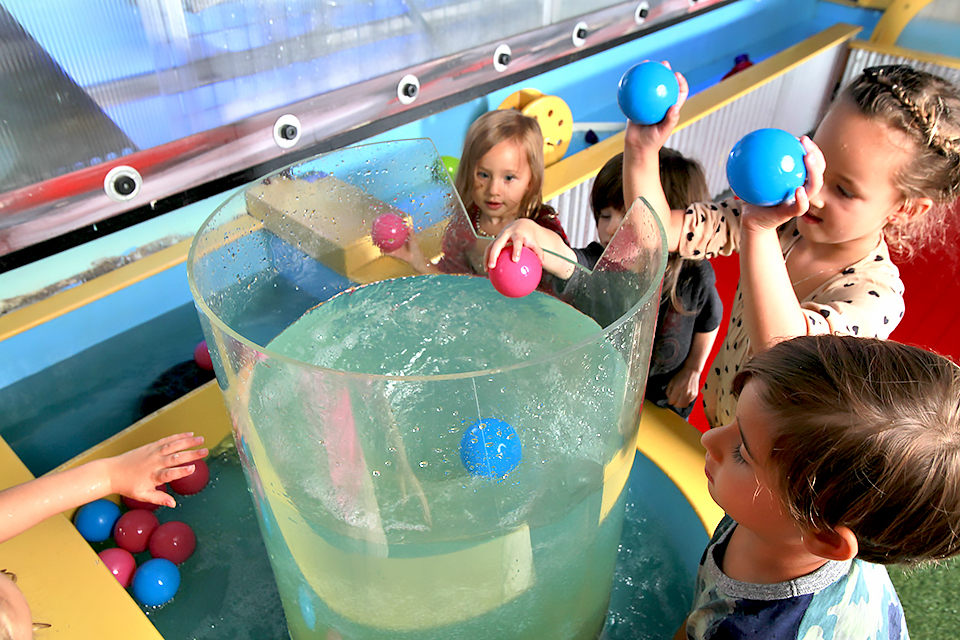 Twinkle Playspace's water table let’s kids toss objects into its whirlpool.