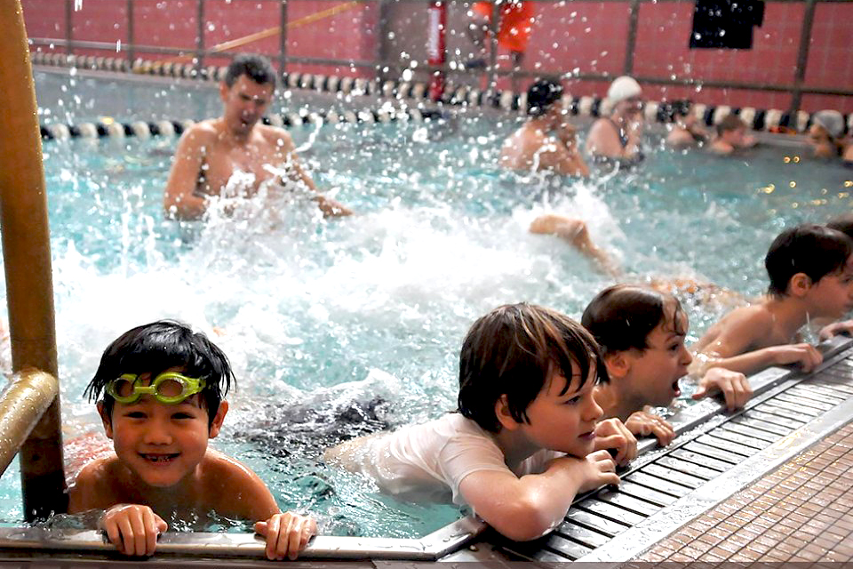 Free swimming lessons in NYC: Kids kicking in swimming pool