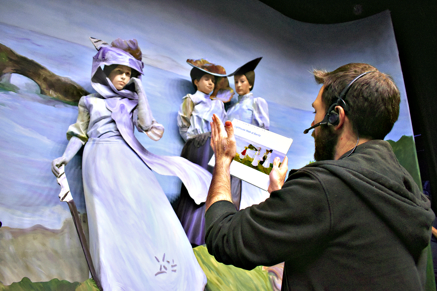 A pageant sculptor helps volunteer cast members into their poses at a rehearsal 