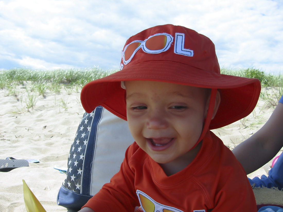 Image of toddler smiling on Cape Cod Beach.