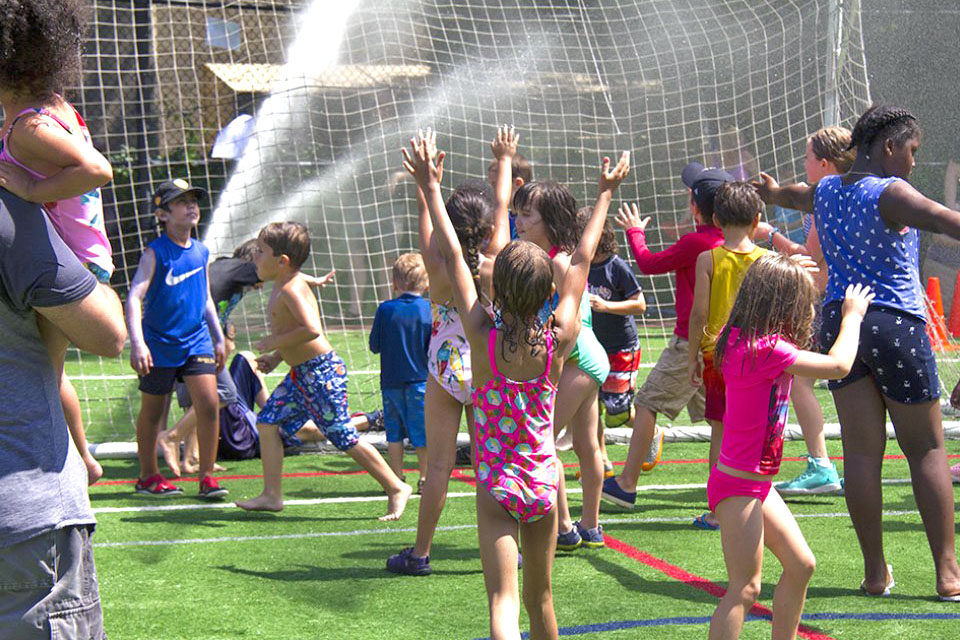 Slip and slide your way to smiles during Asphalt Green's Sprinkler Day. Photo courtesy of Asphalt Green