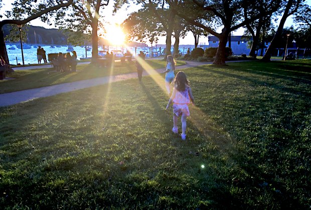 Families gather at Northport Park as the sun sets on the scenic Northport Harbor. Photo by the author