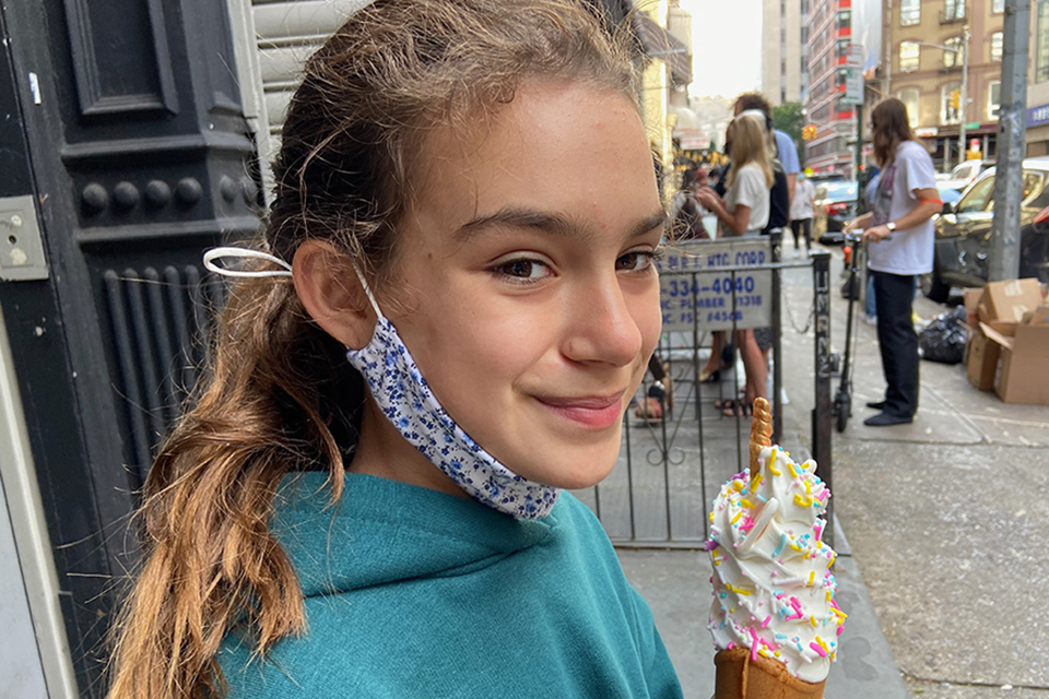Taiyaki NYC. girl eating a unicorn ice cream in a fish shaped cone