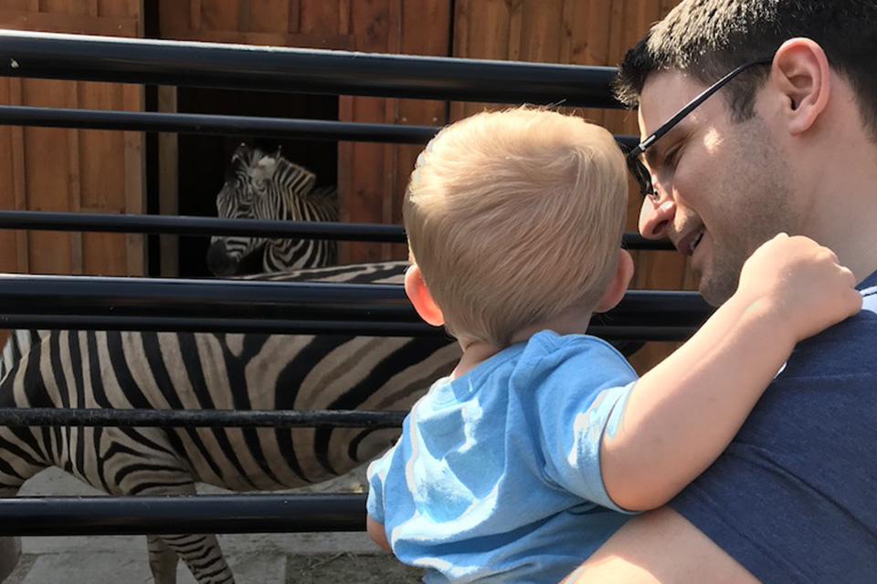Boy and dad looking at zebras at White Post Animal Farm on Long Island